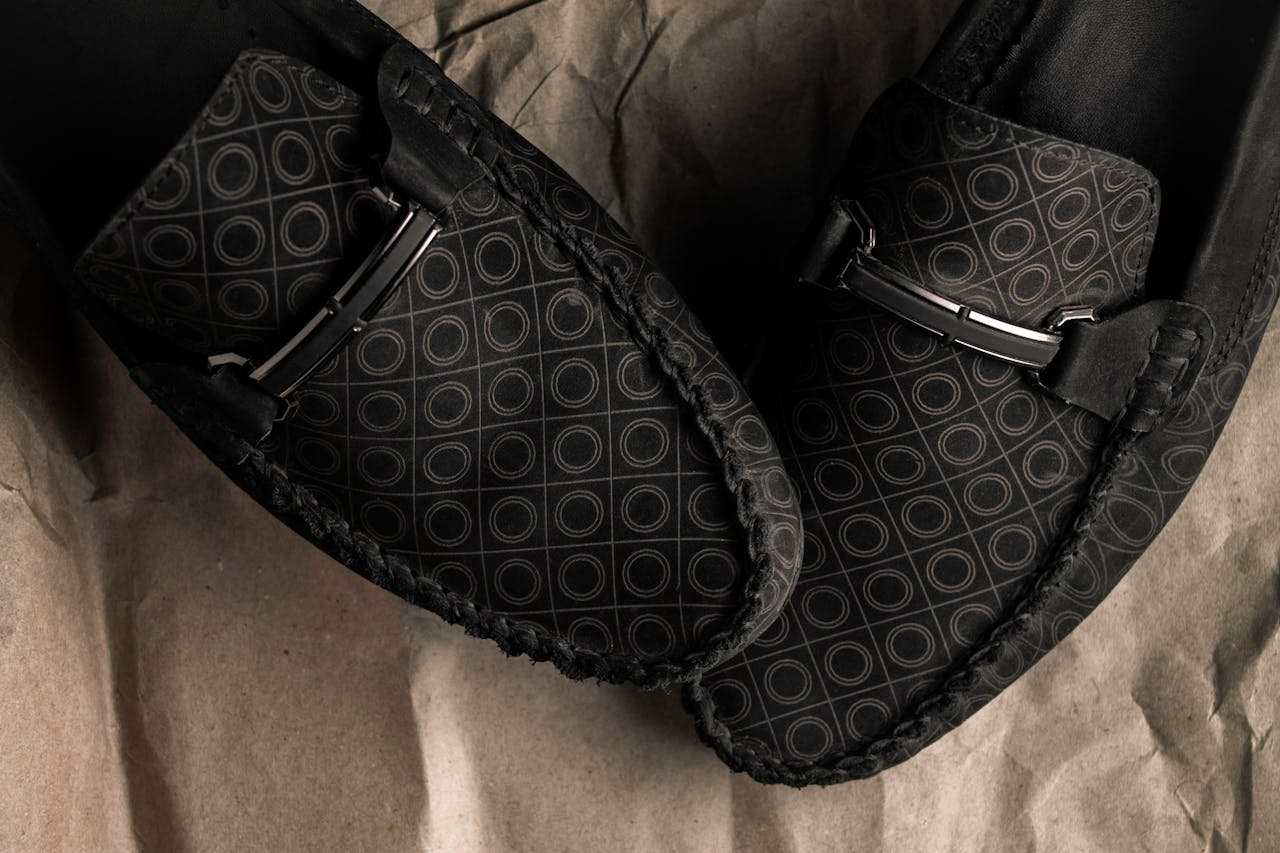 Close-up of stylish black loafers with circle patterns, showcasing elegance and luxury.